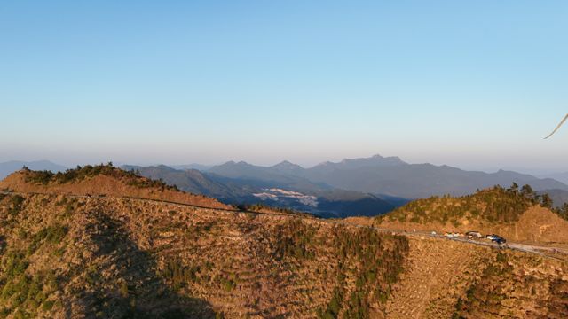 Cars parked on the ridge at sunset