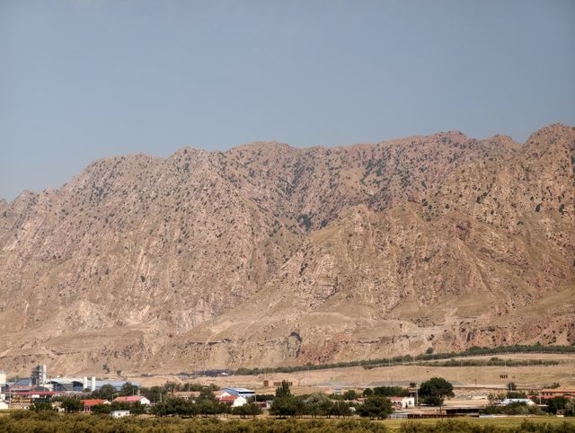 A barren rocky mountain above a small town